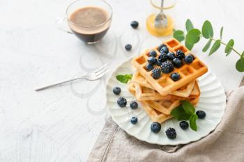 Plate with sweet tasty waffles on white table�