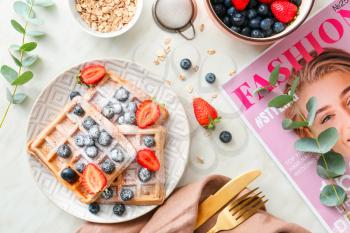 Plate with sweet tasty waffles, berries and oat flakes on table�