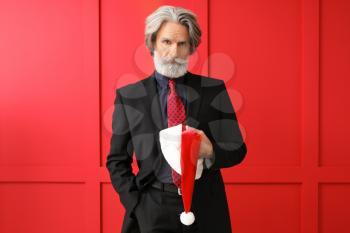 Portrait of stylish Santa Claus on color background�