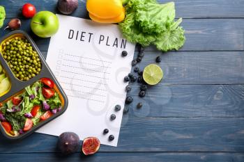 Sheet of paper with diet plan and healthy products on wooden table�