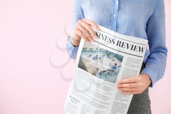 Young businesswoman with newspaper on color background, closeup�