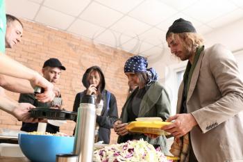 Volunteers giving food to homeless people�