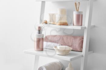 Body care cosmetics with accessories on shelves in bathroom�