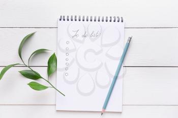 Empty to do list and pencil on white wooden background�