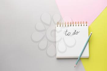 Empty to do list and pencil on color background�