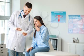 Male gynecologist working with woman in clinic�