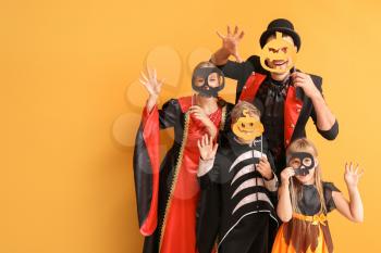 Family in Halloween costumes on color background�