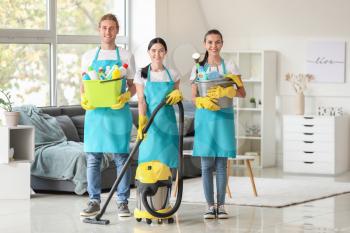 Team of janitors with cleaning supplies in flat�