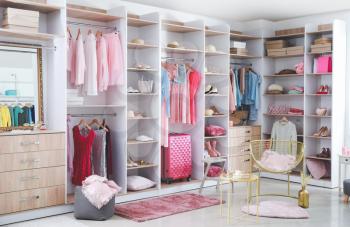 Large wardrobe with modern clothes and accessories in room�