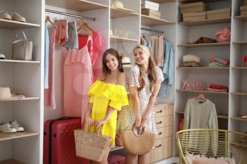 Beautiful young women choosing clothes from large wardrobe�