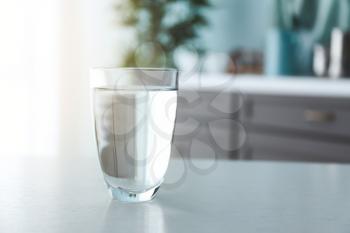 Glass of fresh water on table in kitchen�