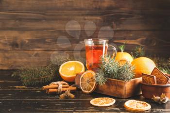 Christmas composition with fresh oranges, tea and cookies on wooden background�