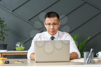 Asian businessman working on laptop in office�