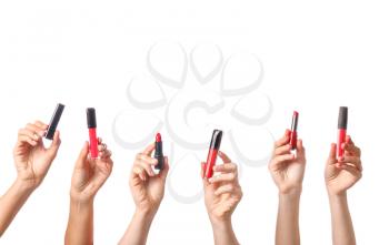 Many hands with decorative cosmetics on white background�