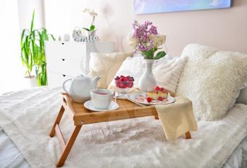 Tray table with tasty breakfast on bed�