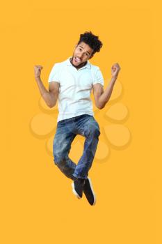 Portrait of jumping African-American man on color background�