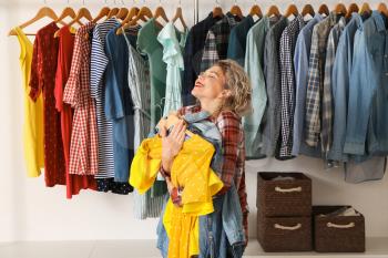 Happy woman with new clothes in store�