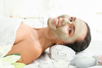 Beautiful woman with facial mask relaxing in spa salon�