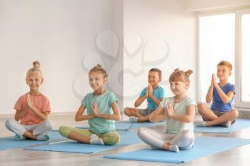Little children practicing yoga in gym�