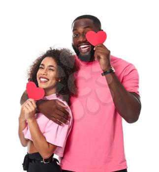 Portrait of happy African-American couple with red hearts on white background�