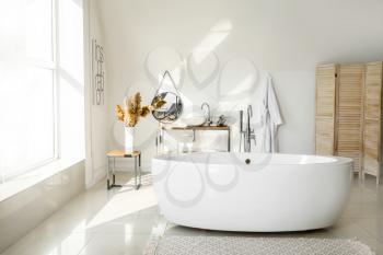 Modern ceramic bathtub in light interior�