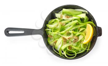 Frying pan with tasty zucchini pasta on white background�