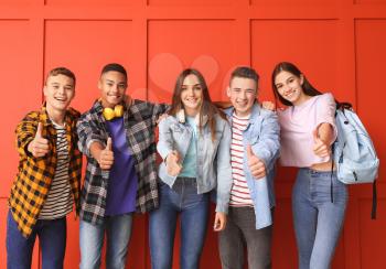 Portrait of teenagers showing thumb-up on color background�