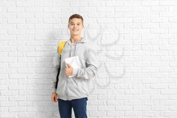 Portrait of teenage schoolboy on brick background�