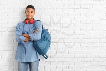 Portrait of African-American teenage schoolboy on brick background�