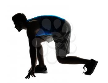 Silhouette of sporty young man in crouch start position on white background�