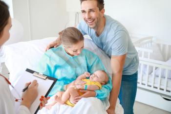 Young family with newborn baby and gynecologist in maternity hospital�
