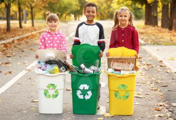 Little children collecting trash outdoors. Concept of recycling�