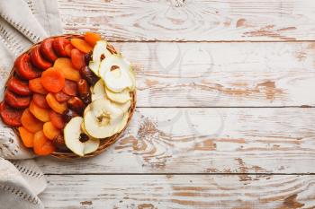 Plate with dried fruits on wooden background�