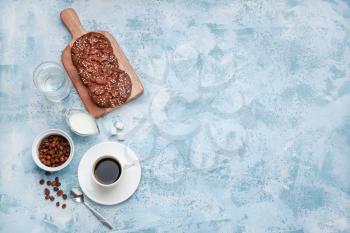 Cup of hot coffee with milk and cookies on color background�