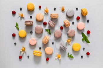 Assortment of tasty macarons on grey background�