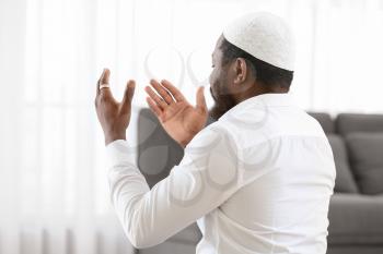 African-American Muslim man praying in office�