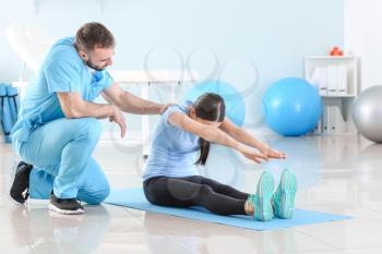 Physiotherapist working with female patient in rehabilitation center�