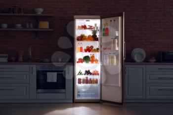 Open refrigerator in dark modern kitchen�