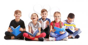Cute little children reading books on white background�