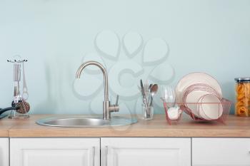 Set of clean dishware near kitchen sink�