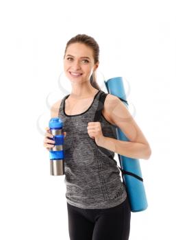 Sporty young woman with yoga mat and bottle of water on white background�