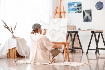 Young male artist working in studio�