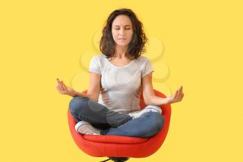 Beautiful woman meditating on color background�