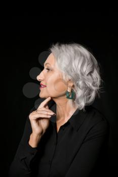 Portrait of stylish mature woman on dark background�