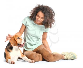 Beautiful African-American woman with cute dog on white background�