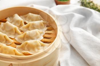 Bamboo steamer with tasty Japanese gyoza on table�