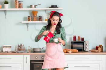Portrait of beautiful pin-up woman with coffee in kitchen�