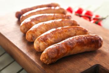 Tasty grilled sausages wooden board, closeup�
