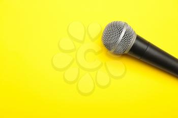 Modern microphone on color background�
