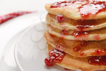 Stack of tasty pancakes with jam on plate, closeup�